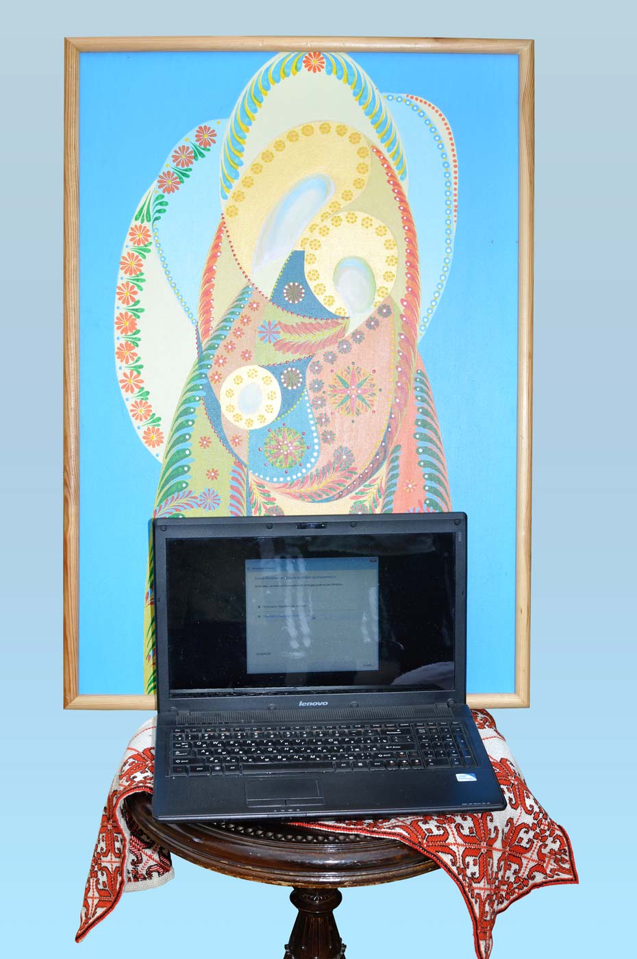 An old laptop on the piano chair with religious painting on the background